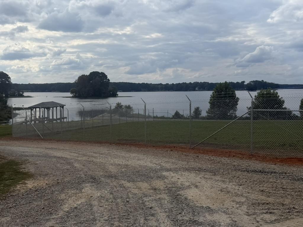 Long run of new chain-link security fence along a gravel access road