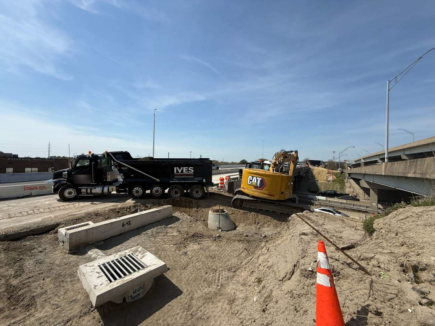 Ives dump truck and excavator on a roadway drainage job